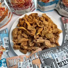 a white plate topped with cheetos next to two bags of cheese pizza chips