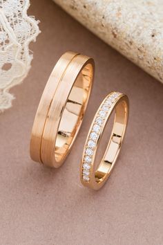 two gold wedding bands with diamonds on them