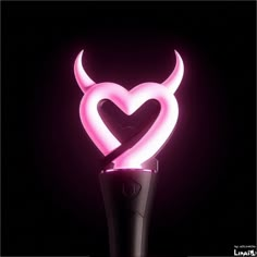 a pink light up devil's head on top of a black object with horns