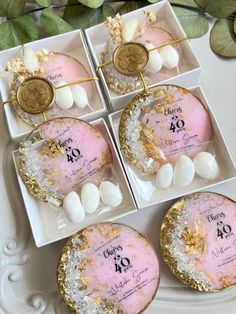 four pink and gold decorated cakes in boxes