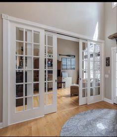 an open living room with french doors and hardwood floors