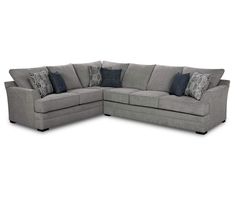 a gray sectional couch with pillows on the top and bottom corner, in front of a white background