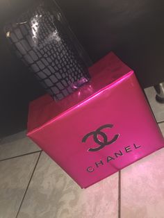 a pink chanel box sitting on top of a tiled floor