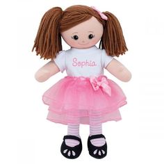 a doll with brown hair wearing a pink tutu skirt and black shoes is standing in front of a white background