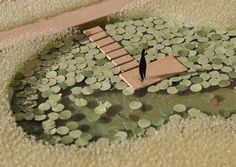 a small wooden bridge over a pond filled with coins