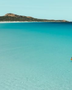 two people are in the water with their surfboards and one person is paddling