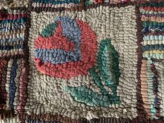 a close up view of an old rug with many different colors and designs on it