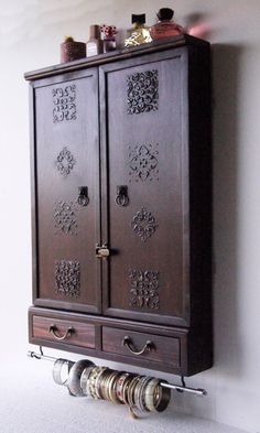 a wooden cabinet with two drawers on the bottom and one door open to reveal coins