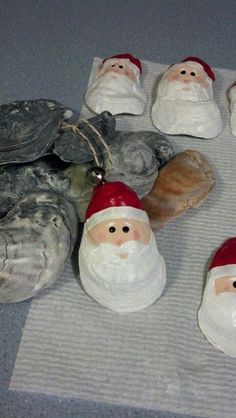 small ceramic santas sitting on top of a table next to rocks and a turtle