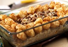 a glass casserole dish filled with food on top of a wooden table