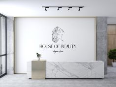 a white marble reception desk in front of a wall with the words house of beauty on it