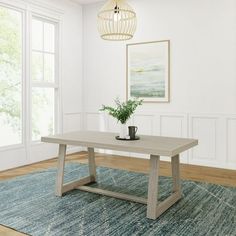 a white table sitting on top of a blue rug next to a lamp and window