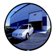 a white car parked in front of a blue building with a garage door and windows