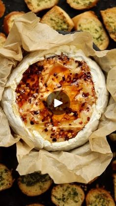 an overhead view of a baked dish with cheese and other food items in the background