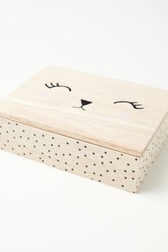 a wooden box with a cat's face drawn on it