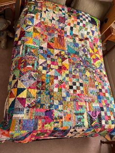 a bed with a colorful quilt on top of it