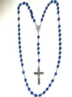 Rosary made with 6mm Glass Sapphire Beads.  Center is 3/4 inch  Center is Miraculous Mother Mary with blue inlay.  Cross is inch.  Eye-pins are stainless steel and chain is silver oxidized. Cross and center are silver oxidized and made in Italy. Comes with a black pouch with or without cross on it and gift box. Please specify in messages if you want a cross on the pouch. If you want more quantity of this rosary just message me and I will do a custom order for you Blue Crucifix Necklace For Spiritual Wear, Blue Crucifix Necklace For Spiritual Purposes, Blue 108 Beads Spiritual Rosary, Spiritual Blue Rosary With 108 Beads, Blue Cross Spiritual Necklace, Blue Cross-shaped Jewelry With 8mm Beads, Blue Cross Jewelry With 8mm Beads, Spiritual Blue Rosary With Round Beads, Spiritual Blue Necklace With Oval Beads