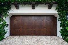 an image of a garage door with vines growing on the wall and brick flooring