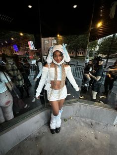 a woman dressed in white is standing outside