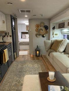 a living room filled with furniture next to a kitchen and stove top oven in a home