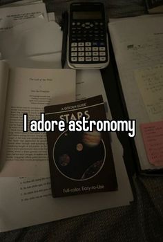 the text reads i adore astronomy in front of an open book and calculator