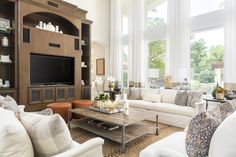 a living room filled with furniture and a flat screen tv mounted on a wall above a fireplace