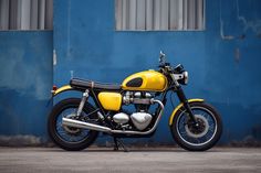 a yellow motorcycle parked in front of a blue building