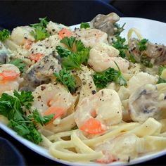 pasta with shrimp, carrots and parsley in a white bowl