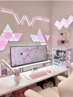 a desk with a computer, keyboard and chair in front of pink triangles on the wall