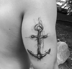 a black and white photo of an anchor tattoo on the left side of his arm