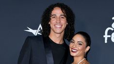 a man and woman standing next to each other on a red carpet at an event