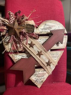 a heart shaped wooden decoration sitting on top of a red chair