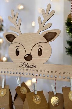 a wooden reindeer ornament hanging on a wall next to small boxes with numbered numbers