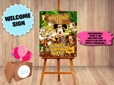 a welcome sign to mickey mouse's birthday party on an easel with balloons