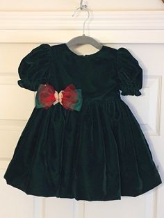 "One of a kind little girl's forest green Lyons velvet dress. Perfect for any special occasion including Christmas, birthdays, weddings and photo shoots!  Stunning for the fall and winter. Features: * Bow made out of red sparkle sheer and green satin * Built-In slip * Extra full tulle skirt * Top fully lined * Puff sleeves with ruffles Size: 3 Chest: 22\" Waist: 21 1/2\" 100% handmade small business. This dress is my original design so know that your little girl will be wearing a dress like no o Dark Green Velvet Dress, Dark Green Velvet, Full Tulle Skirt, Green Velvet Dress, Dress Tulle, Red Sparkle, Handmade Dress, Handmade Dresses, Green Satin