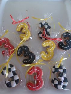 decorated cookies in the shape of numbers are tied with ribbons and placed on a tray