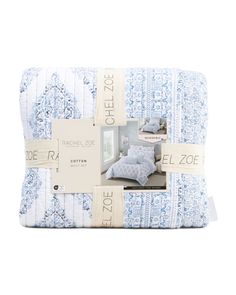 the blue and white bedspread is folded in two rows, with an image of a