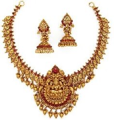 a gold necklace and earrings set with red stones