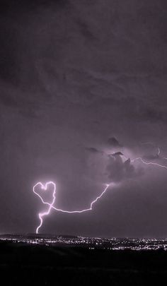 a lightning bolt is seen in the sky over a city