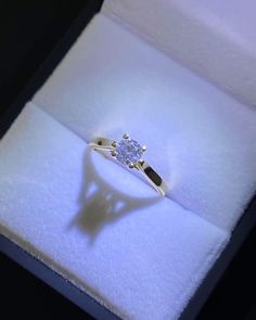 an engagement ring in a white box