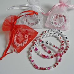 three personalized bracelets in various colors and designs, one with name beads on it