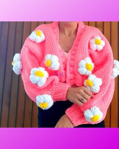 a woman wearing a pink sweater with white flowers on the front and yellow petals on the back