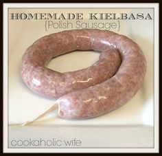 a large sausage sitting on top of a white counter next to a sign that says homemade kielbasa polish sausage