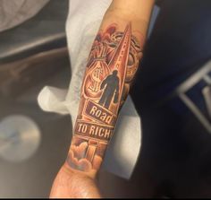 a man with a tattoo on his arm that says road to rich and an image of a rocket ship