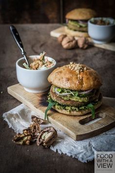 a large sandwich sitting on top of a cutting board next to a bowl of food