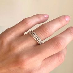 a woman's hand with a diamond ring on top of her finger, showing the band