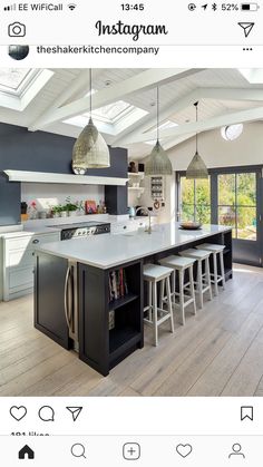 a large kitchen with an island in the middle and lots of stools around it