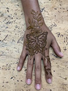 a person's hand with hennap and flowers painted on the top of it