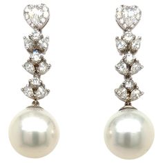 Glamorous South Sea Pearl earrings. High pearly luster, silver overtone, 13mm natural South Sea matching pearls, accented with pear shape and round brilliant cut diamonds. Handcrafted design set in 18 karats white gold with post and butterfly back. South Sea Pearl: 13mm, high luster, silver overtone Diamond: 2.51 carats round brilliant cut & pear shape Color: F-G Clarity: VS1-Si2 Dimensions: 42mm x 13mm (approx) Luxury Traditional Pearl Earrings For Pierced Ears, Pear-shaped Diamond Earrings For Formal Events, Luxury Diamond Pearl Earrings For Formal Events, Luxury Diamond Pearl Earrings For Formal Occasions, Luxury Diamond Earrings With Pearl Drop, Formal Diamond Pearl Earrings With Brilliant Cut, Formal Brilliant Cut Diamond Pearl Earrings, Luxury Teardrop Pearl Earrings With Diamond Accents, Luxury White Pearl Diamond Earrings