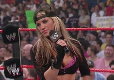 a female wrestler holding a microphone in front of a crowd